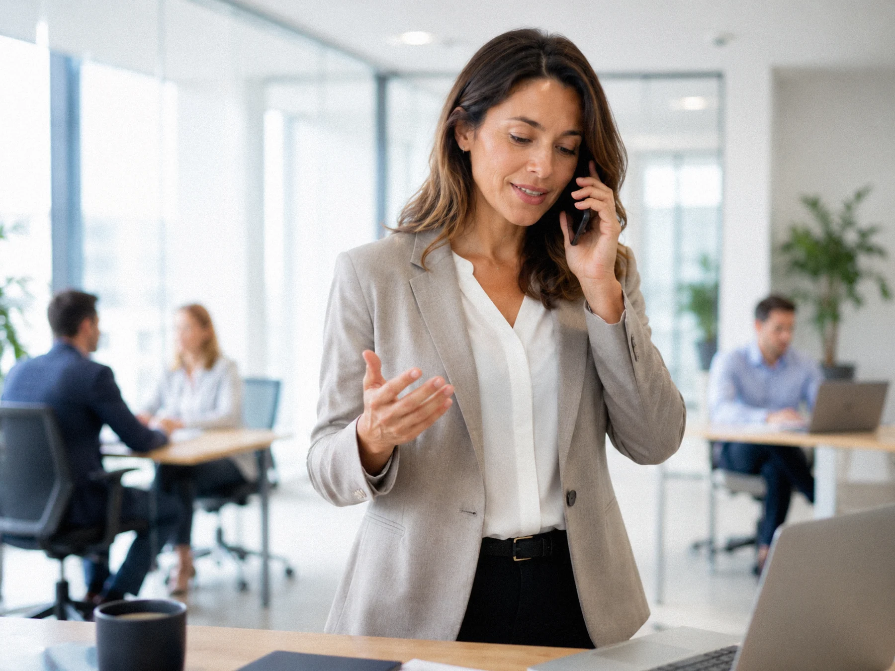 Frau im geschäftlichen Telefongespräch in einem hellen Büro